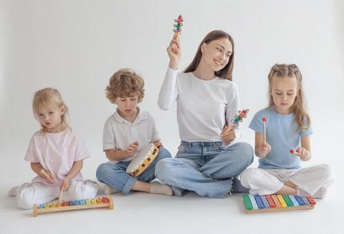 真剣に演奏する子供を見る笑顔の女性 男女,女性,女の子の写真素材