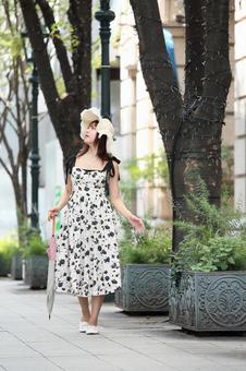 ケヤキ並木の舗道を歩く女性 ケヤキ並木の舗道を歩く女性の写真