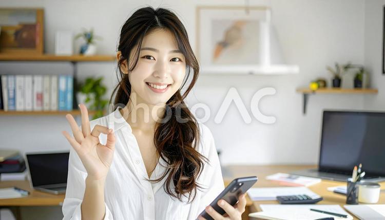 家計がうまくいきスマホ片手に微笑む女性 パソコン,家計簿,節約の写真素材