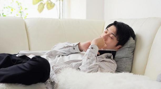 スマホを見ながら寝落ちするアジア人男性 スマホを見ながら寝落ちするアジア人男性 スマホ,スマートフォン,寝落ちの写真素材