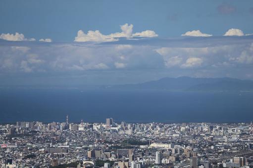 市街地の街と海と霞む半島と青空と雲の風景 市街地の街と海と霞む半島と青空と雲の風景の写真