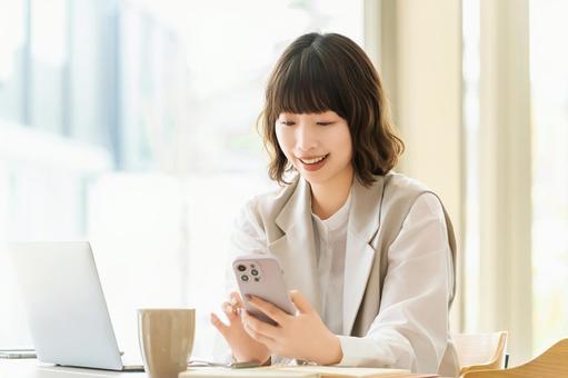 スマホを使う笑顔の女性・ビジネスウーマン スマホを使う笑顔の女性・ビジネスウーマン 女性,スマホ,スマートフォンの写真素材