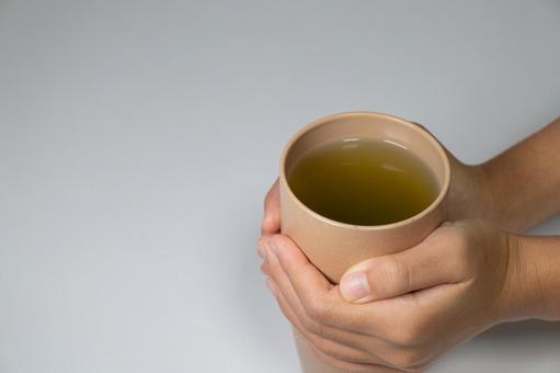 温かいお茶を両手で持つ お茶,温かい,手の写真素材
