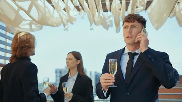 シャンパングラスを持ち通話中の男性 男女,外国人,スマートフォンの写真素材