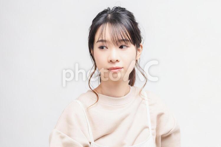 白い背景の前に立ってポーズをとる若い女性 女性,白背景,立つの写真素材