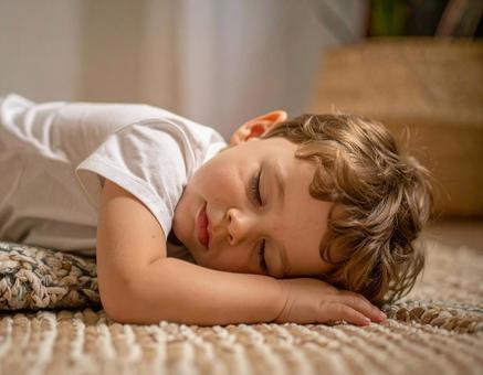 遊び疲れて床で眠ってしまった子供2の写真