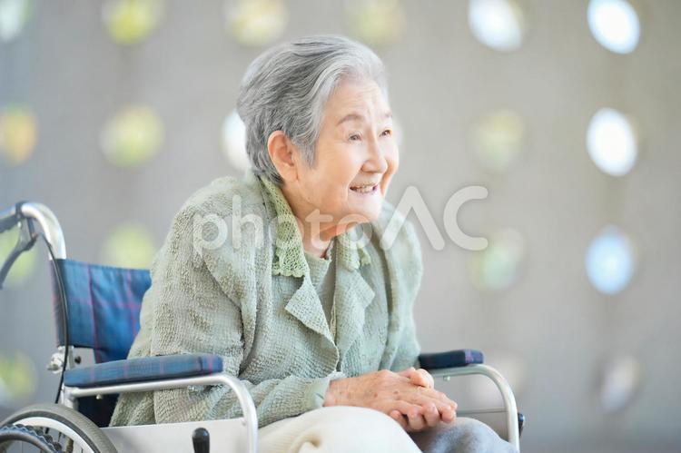 車椅子に座って身を乗り出して話すおばあちゃん 女性,おばあちゃん,話すの写真素材