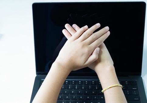 ノートパソコンの画面の前で交差する両手 パソコン,ノートpc,セキュリティの写真素材