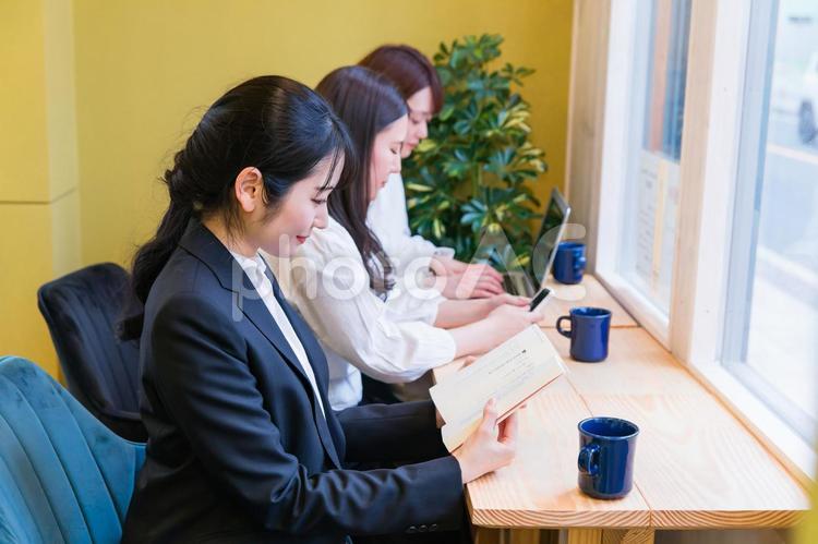 カフェの窓際カウンター席にいる女性（読書） 本,資格,読書の写真素材