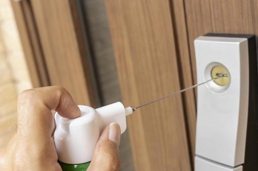 鍵穴にスプレーで潤滑剤を入れるイメージ 鍵穴にスプレーで潤滑剤を入れるイメージ カギ,鍵穴,ロックの写真素材