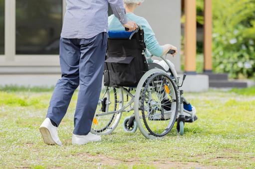 住宅の前を歩く車椅子に乗ったシニア夫婦 住宅の前を歩く車椅子に乗ったシニア夫婦 シニア,車椅子,老人ホームの写真素材