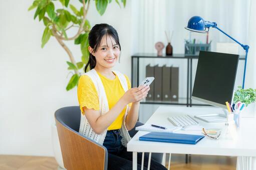 スマホを操作する若い女性 ビジネスウーマン,若い女性,笑顔の写真素材