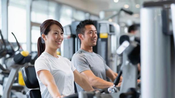 ジムでトレーニングする男女のフィットネスの写真