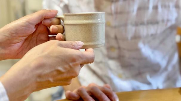 高齢女性に飲み物介助する女性の手 高齢女性に飲み物介助する女性の手 飲ませる,水分補給,飲み物の写真素材