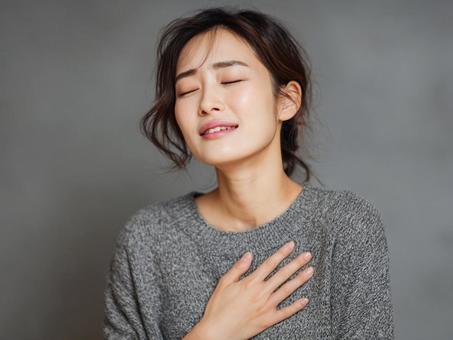 胸に手を当てる女性 胸に手を当てる女性の写真