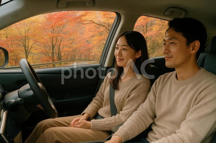 車内で会話を楽しむカップルと秋の風景 電気自動車,ev,車内の写真素材