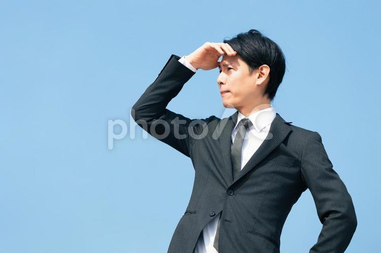 日差しを手で遮る男性ビジネスマン 男性,夏,暑いの写真素材