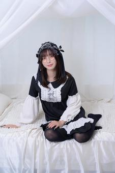 ベッドに腰掛けるメガネの地雷系女子 ベッドに腰掛けるメガネの地雷系女子 眼鏡,メガネ,20代の写真素材