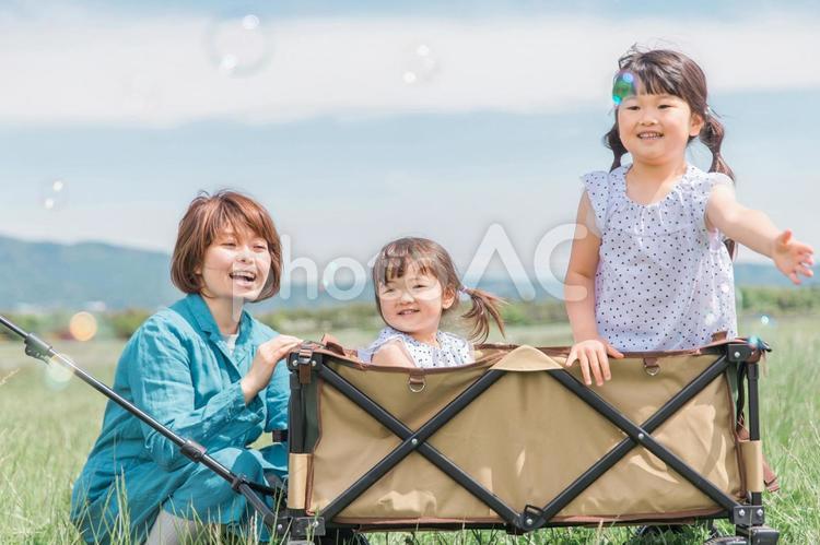 公園でシャボン玉で遊ぶ姉妹の女の子とママ 親子,子供,シャボン玉の写真素材
