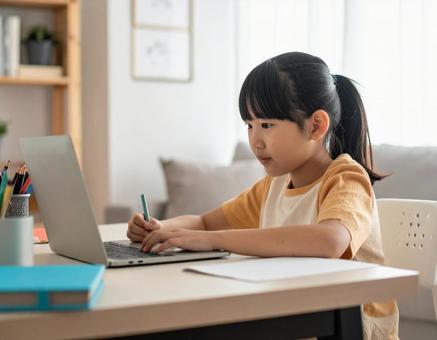 パソコンで勉強する小学生の女の子 パソコンで勉強する小学生の女の子の写真