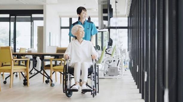 車椅子で散歩をする高齢者と介護士 車椅子で散歩をする高齢者と介護士 高齢者,車椅子,介護士の写真素材