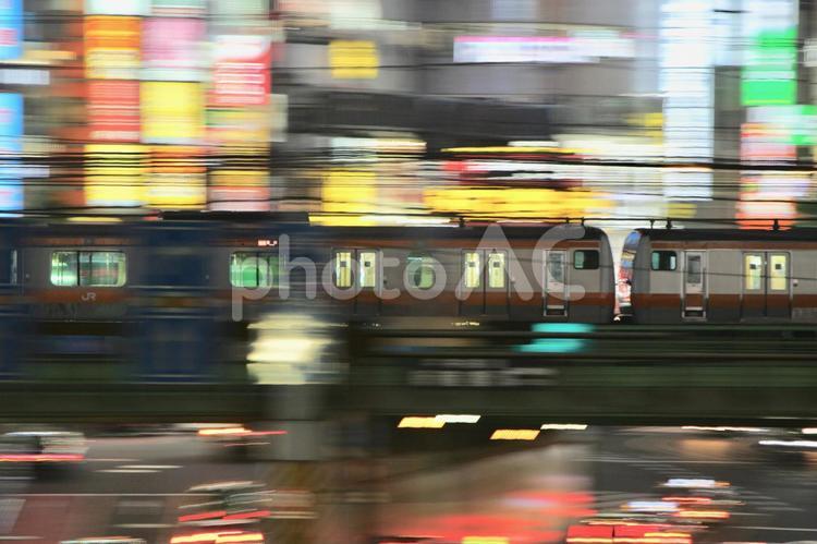 繁華街を疾走する電車 鉄道,鉄道写真,繁華街の写真素材