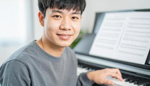 音楽指導者を目指すピアノを弾く男性 音楽指導者を目指すピアノを弾く男性の写真