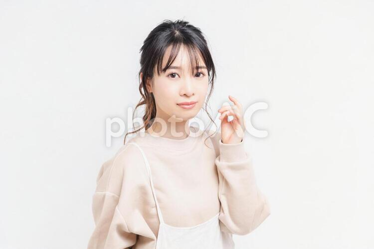 白い背景の前に立ってポーズをとる若い女性 女性,白背景,立つの写真素材