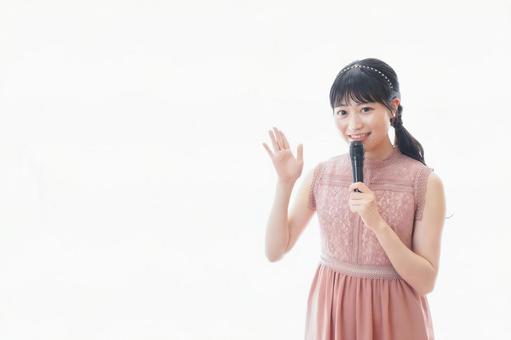 パーティーで司会をする若い女性 パーティーで司会をする若い女性の写真