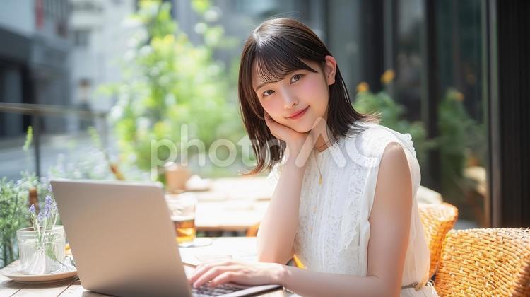 緑豊かなカフェでノートPCを使用する女性 カフェ,女性,ノートパソコンの写真素材
