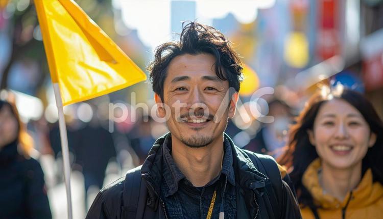 旗を持って旅行客を導く男性の旅行添乗員 ツアーガイド,旗,ビジネスの写真素材