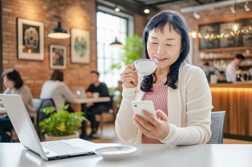 喫茶店でコーヒーを飲む女性 喫茶店でコーヒーを飲む女性 女性,笑顔,カフェの写真素材