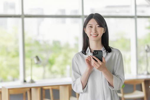 スマホを持つ若い女性 スマホを持つ若い女性の写真