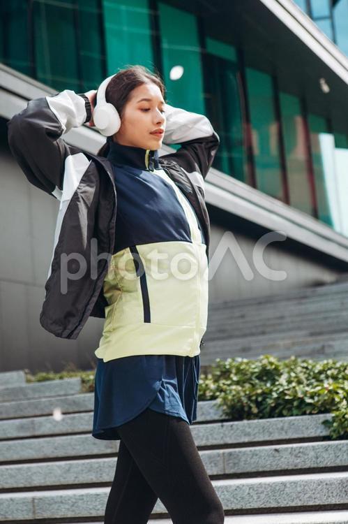 腕を頭に置いて足を伸ばす女性 女性,ヘッドフォン,人物の写真素材