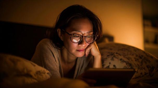 夜に画面を見る女性 夜に画面を見る女性の写真