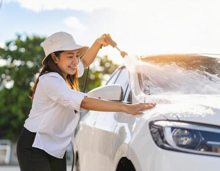手洗い洗車中の女性 手洗い洗車中の女性の写真