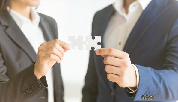 ジグソーパズルを持つビジネスパーソン ジグソーパズルを持つビジネスパーソンの写真