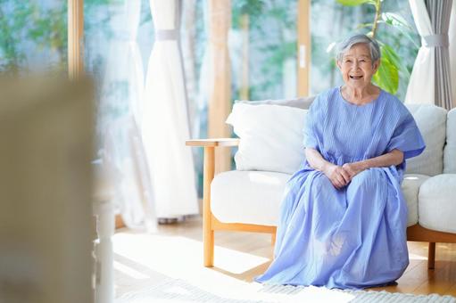 ソファに座り笑うワンピースの高齢女性 女性,ソファ,座るの写真素材