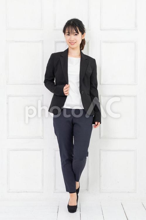 白い部屋に立ってポーズをとる、ジャケットを着た若い女性 女性,立つ,ジャケットの写真素材