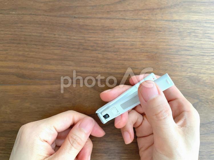 机上で爪を切る女性の手元 爪切り,手,ネイルケアの写真素材