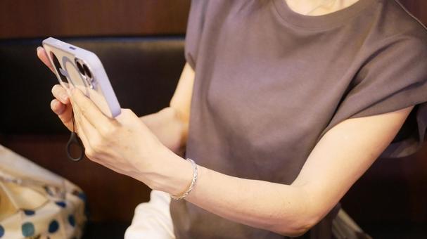 スマホを操作する女性 スマホを操作する女性の写真