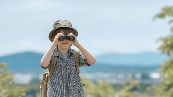 双眼鏡を見る少年、バードウォッチングの写真