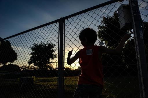 <素材>フェンス越しに夕日を眺める男の子 <素材>フェンス越しに夕日を眺める男の子 子供,男性,人物の写真素材