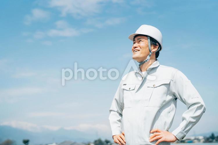 青空と作業服を着た男性 作業員,作業服,工事の写真素材