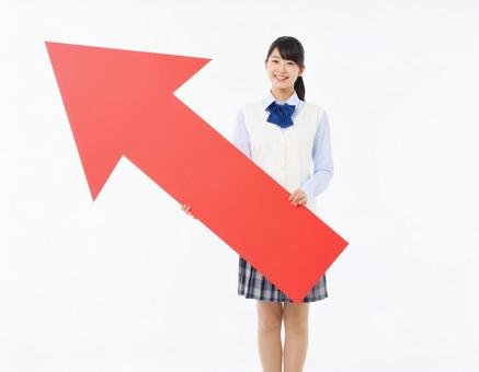 上向きの矢印を持つ女子生徒 上向きの矢印を持つ女子生徒の写真
