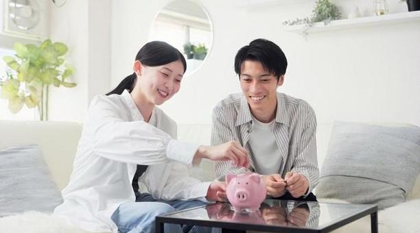 貯金箱にお金を入れるアジア人のカップル 貯金箱にお金を入れるアジア人のカップル 貯金,カップル,女性の写真素材