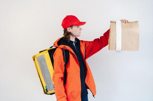 紙袋を持つフードデリバリーの男性（白背景） 配達,フードデリバリー,デリバリーの写真素材