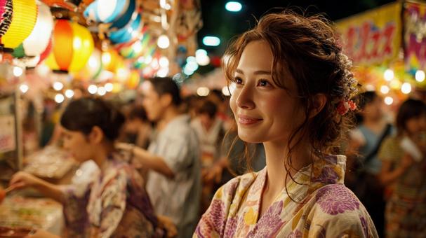 夏祭りの夜に屋台を歩く浴衣姿の女性 夏祭りの夜に屋台を歩く浴衣姿の女性の写真