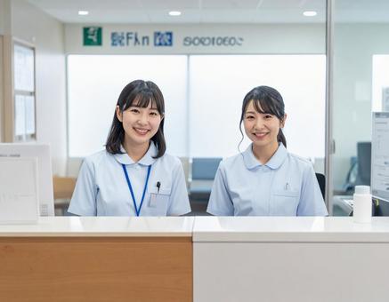 病院の受付コーナーで笑顔で迎える受付嬢 病院の受付コーナーで笑顔で迎える受付嬢の写真