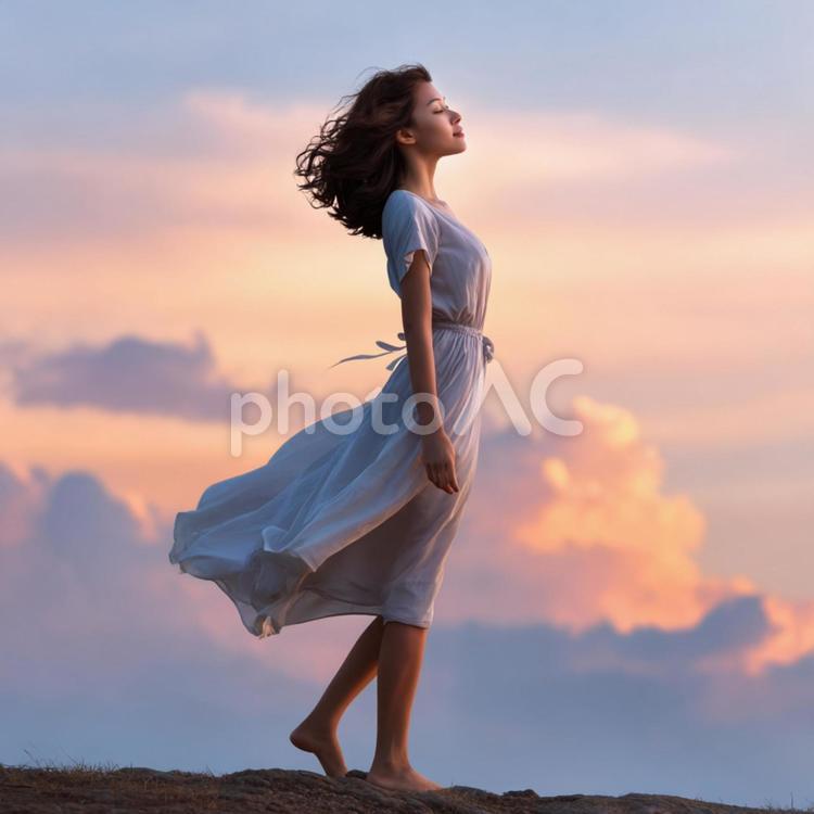 美しい夕焼けに包まれた女性のシルエット 女性,若い女性,白いドレスの写真素材